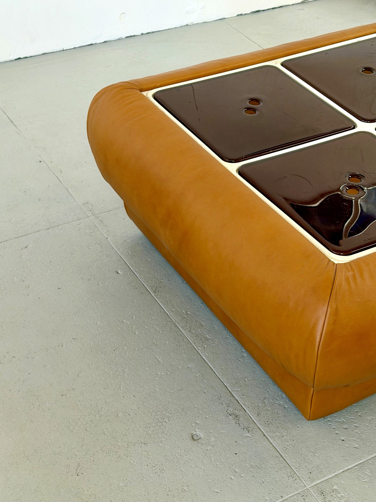 Front corner detail of tan leather Nuvolone coffee table